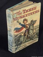 Front and spine view of worn hardcover with taped spine