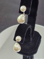 Front view showing both earrings on display stand