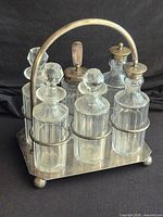 Full view of cruet set showing six bottles and metal stand