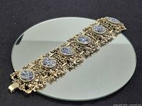 Full view of bracelet showing six blue cabochons and filigree links