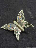 Front view of gold tone butterfly brooch with multicolor rhinestones