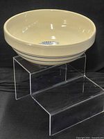Overall view of cream ceramic bowl on display stand