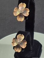 Front view showing both flower earrings on stand