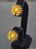 Front view of both orange and yellow enamel floral earrings
