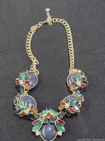 Full view of gold-tone necklace with multicolor stones and extender chain