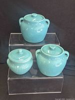 Front view of all three turquoise glazed ceramic jars with lids
