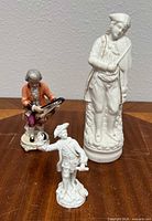 Group shot of all three porcelain figurines standing on wood surface