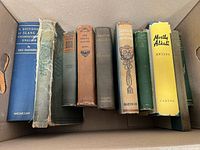 Nine upright books plus one lying flat showing spines and covers