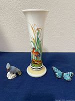Front view of vase, stone bird, and butterfly