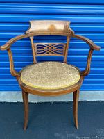 Front view of inlaid tub armchair showing overall form, curved arms, upholstery