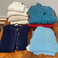 Group shot of all eight sweaters folded on table