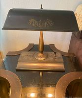 Front view of bronze desk lamp showing shade overlay and base pen tray