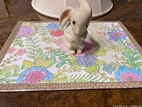 Ceramic bunny on floral placemat, full view