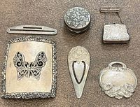 Six silver pieces arranged on surface