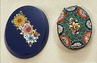 Front view of both micro-mosaic pieces showing floral tesserae designs and shapes