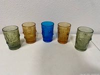 Front view of all five multicolor pressed glass tumblers