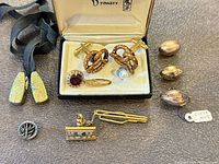Group shot of all accessories including cufflinks, pins, charms, tie clip and collar tips