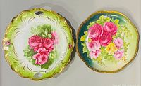 Two round hand painted porcelain plates with rose motifs