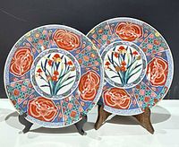 Front view of both matching Shibata Toki Imari plates on stands