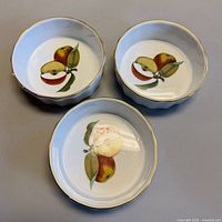 Top view of three bowls showing fruit motif and gold rim