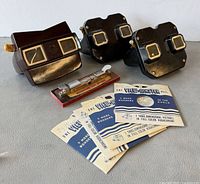Group shot of three View-Master viewers, stapler, and reel sleeves
