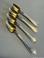 Four matching sterling silver teaspoons shown front view