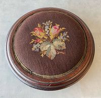 Top view showing floral needlepoint upholstery and wooden frame