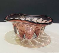 Oblique view showing wavy rim, amethyst color, clear starburst base