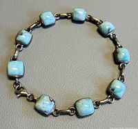 Full view of circular bracelet showing eight larimar stones and clasp