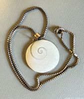 Necklace coiled showing pendant front and box chain