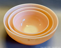 Side view of three nested peach luster Fire King bowls