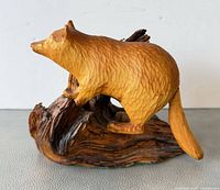 Left side view of carved wooden raccoon on root base