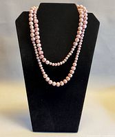 Necklace doubled on black display showing graduated pink pearls