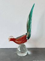 Full side view of red and green Murano glass pheasant on clear bubble base