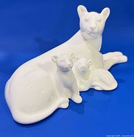 Front angled view of white porcelain lioness and cubs figurine