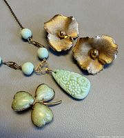 Earrings, brooch and necklace laid out together