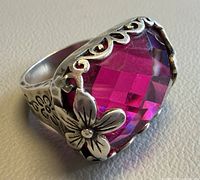 Oblique view showing pink stone and floral silver setting