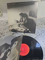 Front jacket displayed upright behind vinyl and inner sleeve