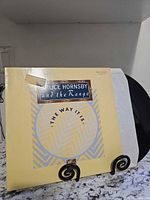 Front cover of album on stand with record partially exposed