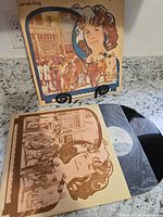 Front cover and record partially removed in illustrated inner sleeve