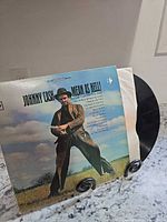 Front cover of Johnny Cash “Mean As Hell!” LP displayed on stand with vinyl partially visible