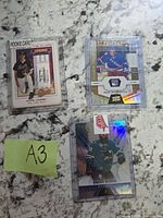 Overall view of the three sleeved sports trading cards on countertop