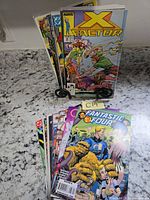 Front and rear stacks of comic books showing X-Factor and Fantastic Four covers