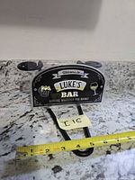 Front view of sign showing full text and graphics with tape measure for scale