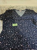 Full view of navy scrub top laid flat