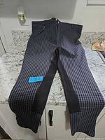 Full view of breeches laid flat showing check pattern and knee patches