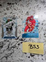 Both trading cards front view showing players, team logos, serial numbers