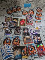 Full spread of mixed sports cards laid out showing quantity and variety