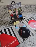 Slipcover, open tri-fold wallet, and three discs visible