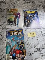 Overview of all three bagged DC comic books on countertop